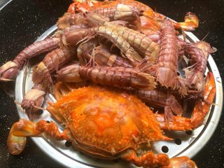 家庭版海鲜大咖,蒸锅水开，放入螃蟹和虾姑蒸12分钟，至螃蟹和虾姑熟透取出待用