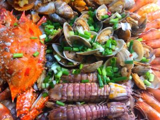 家庭版海鲜大咖,把煮花蛤剩下的汤汁浇到海鲜上，撒上葱花