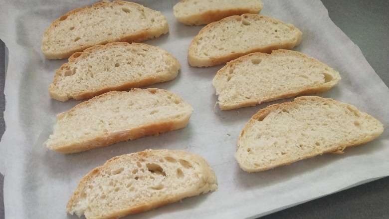 蒜香面包,牛奶欧包切成约1cm厚度的片，放入垫有油纸的烤盘中。