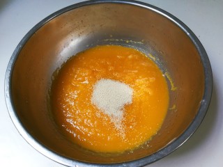 南瓜荷叶饼,将南瓜泥倒入盘中，再放入发酵粉拌匀
