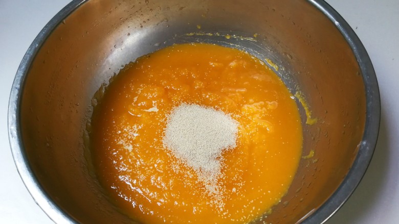 南瓜荷叶饼,将南瓜泥倒入盘中，再放入发酵粉拌匀