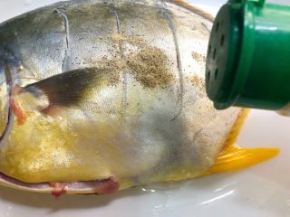 清蒸金鲳鱼,把鱼放入盘里，倒入1g白胡椒粉