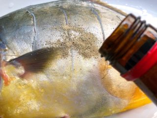 清蒸金鲳鱼,再倒入10g料酒，用手抹均匀，腌制20分钟