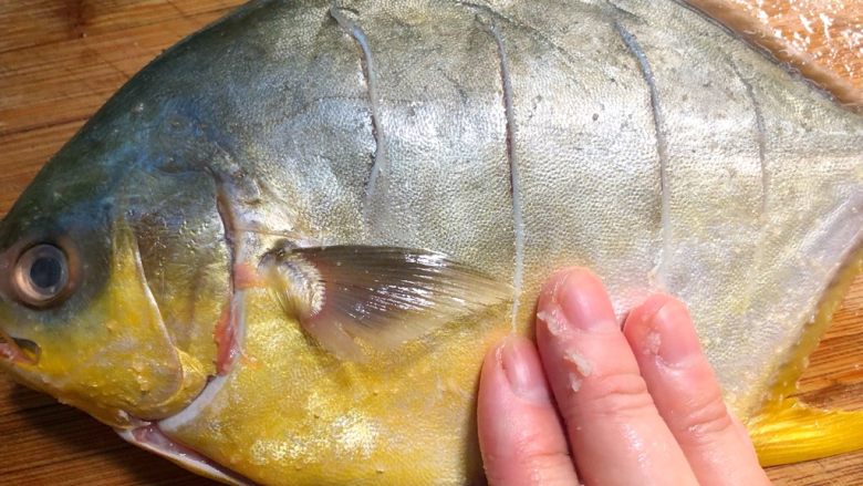 清蒸金鲳鱼,倒1g盐到鱼身上，用手抹均匀