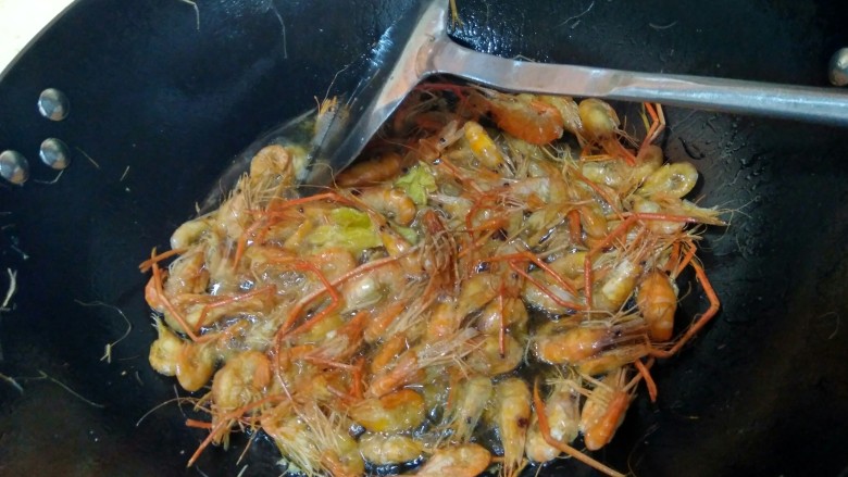 韭苔爆河虾,再次开火，油冒泡时再倒入河虾复炸，使虾更酥脆。