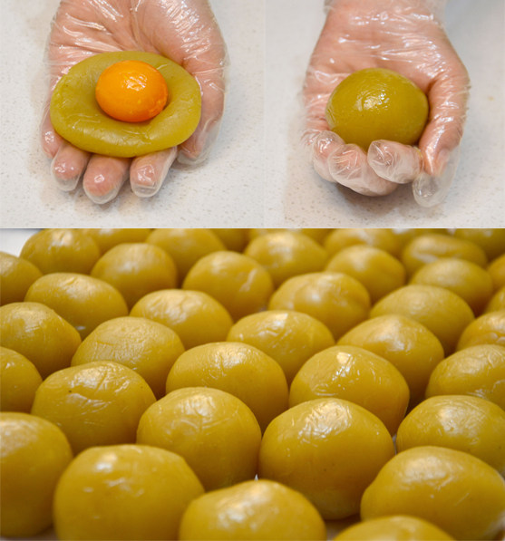 广式蛋黄莲蓉月饼,将蛋黄和莲蓉一起称取约70g每份，将莲蓉压扁后包入蛋黄揉圆。