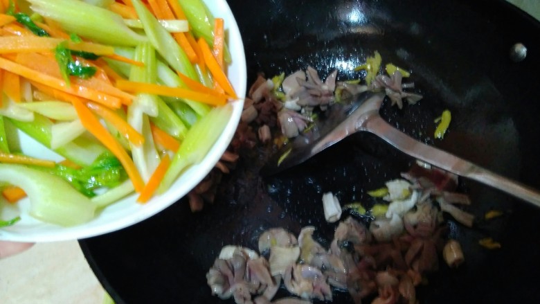 西芹炒鹅胗,接着倒入芹菜胡萝卜翻炒。