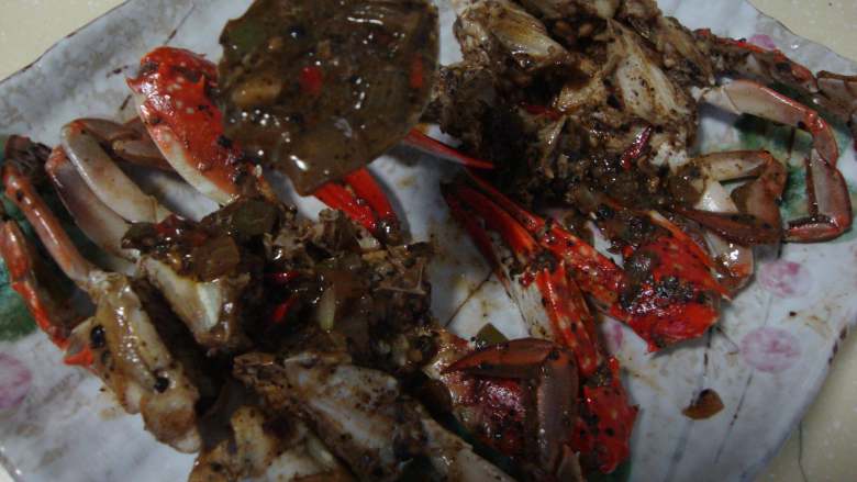 新加坡名菜：黑胡椒蟹,把蟹块码入盘中，浇上汤汁，在把蟹盖盖在上面