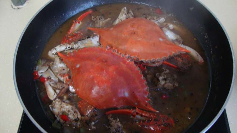 新加坡名菜：黑胡椒蟹,加糖、味精、化好的浓汤盖盖焖5分钟，收汁