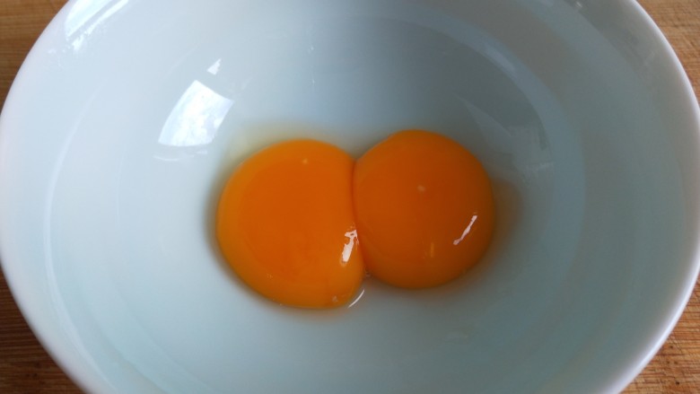 新文美食  花中王牡丹蒸饺,打开鸡蛋，取出来两个蛋黄搅拌均匀。