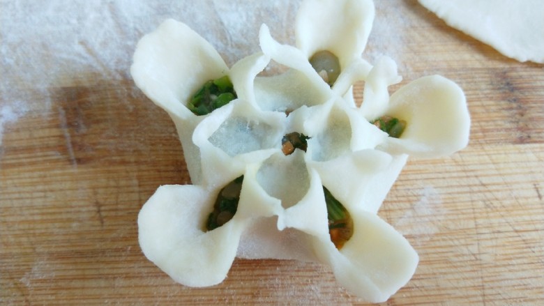新文美食  花中王牡丹蒸饺,在捏出花心。一朵牡丹花就做好了。