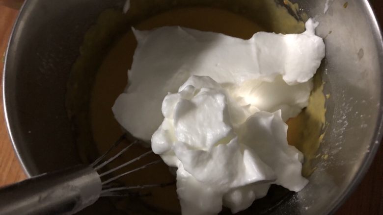 南瓜戚风中空蛋糕,取一部分蛋白放入蛋黄糊中，轻轻搅拌混合均匀。