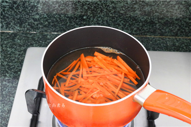 素菜培根卷,烧开适量水，倒入胡萝卜丝