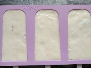 奶油葡萄干雪糕,最后把混合液倒入模具约九分满，再撒些葡萄干。模具盖上盖子，放冰箱冷冻3小时以上