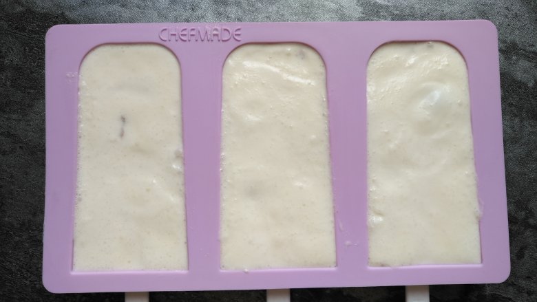 奶油葡萄干雪糕,最后把混合液倒入模具约九分满，再撒些葡萄干。模具盖上盖子，放冰箱冷冻3小时以上