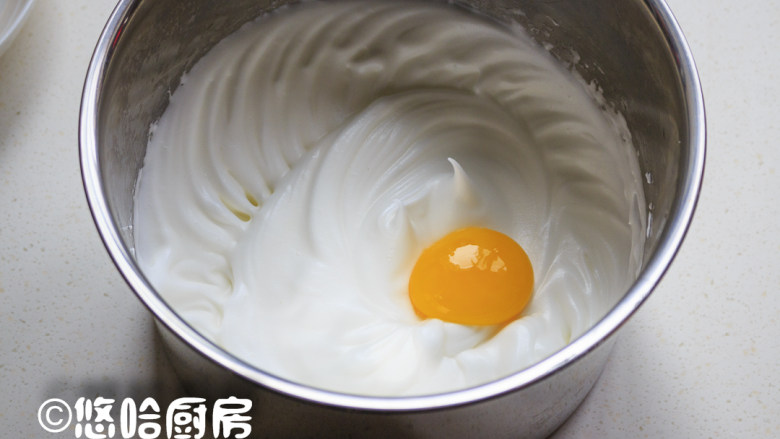 栗子海绵蛋糕,蛋白霜中分次放入蛋黄，用打蛋器搅打均匀后再放入下一个。
