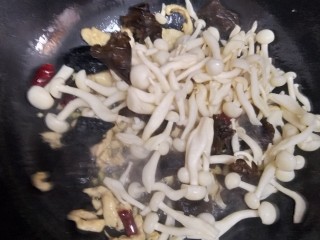 白玉菇木耳炒鸡脯肉,加入洗好的木耳，与蘑菇翻炒