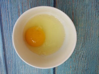玉米火腿鸡蛋汤,把鸡蛋打入碗中。