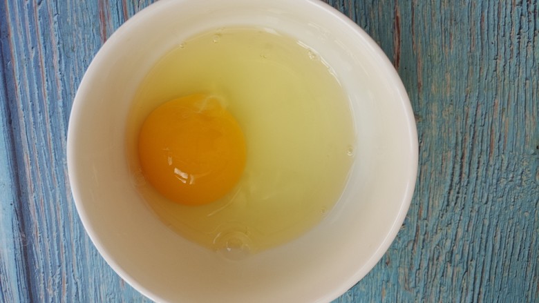 玉米火腿鸡蛋汤,把鸡蛋打入碗中。