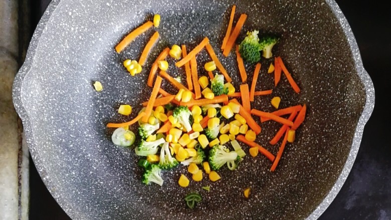 杂蔬贝柱面,倒入西兰花、玉米粒和胡萝卜丝翻炒片刻