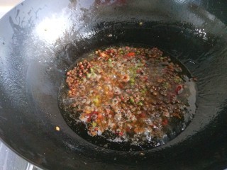 新文美食  川味椒香麻辣鸡块,锅中倒入适量油烧热，放入干花椒炸制微黄。