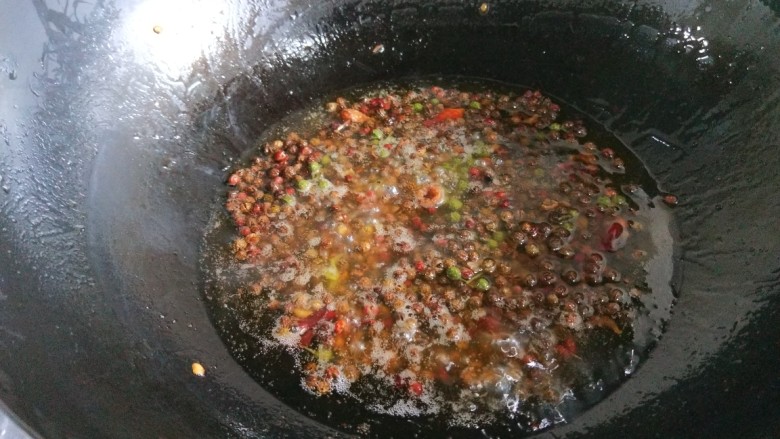 新文美食  川味椒香麻辣鸡块,锅中倒入适量油烧热，放入干花椒炸制微黄。