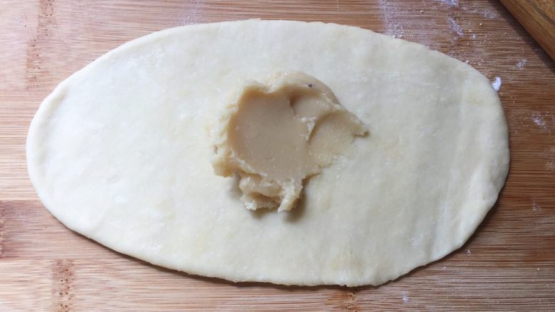 奶香盘丝饼,揉圆，先擀成长牛舌状，放上油酥，抹匀
