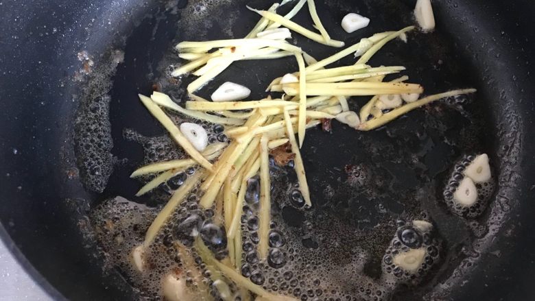 芽芽私房菜～辣炒梭子蟹,锅内留底油，下生姜丝和大蒜片，小火煸香