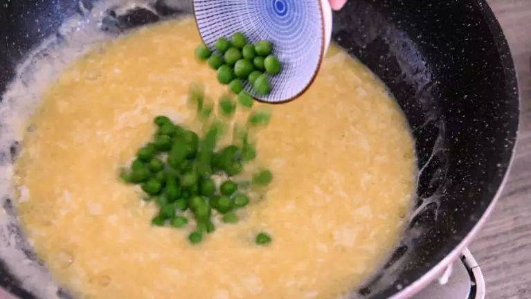 传统鲁菜:溜黄菜 松软香醇 回味无穷,等蛋液凝结，加入豌豆炒匀