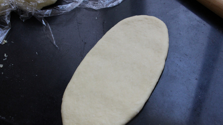 香甜热狗面包,将松弛好的面团擀成椭圆形的长舌状。