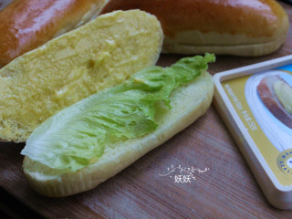 香甜热狗面包,烤好晾凉一下，从中间切开，不需要切断掉，抹上涂抹型黄油，摆上生菜。