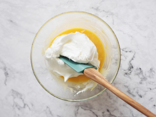 色彩斑斓的炫彩戚风蛋糕,取三分之一的蛋白霜加入到蛋黄糊中，翻拌均匀