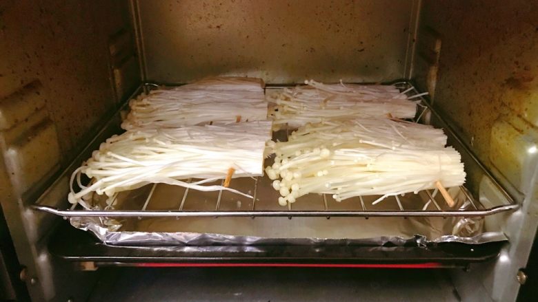 烤金针菇,放入烤箱，下面摆个烤盘，垫上锡纸，水就滴到烤盘上了。上下火，中层，250度，先烤5分钟。