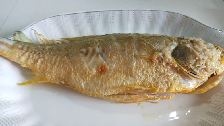 新文美食  红烧黄花鱼,放入盘中，在炸制第二条。