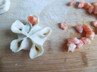 新文美食  梅花虾仁生蒸饺,虾仁切成粒，在把虾粒摆放在花瓣上。
