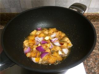 三色回锅肉,放入洋葱和蒜片翻炒30秒。