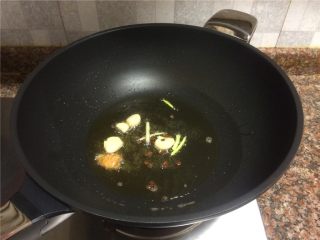香菇丸子烧冬瓜,放入大蒜、生姜、小葱和花椒翻炒出香味。