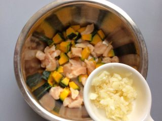 美味低脂: 贝贝南瓜蒸鸡胸肉,南瓜、鸡胸肉、蒜蓉倒入盘子中。