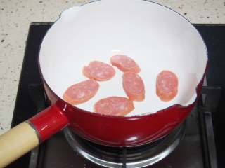 快手蔬菜汤面,锅中放入适量油，将红肠稍微煎一下