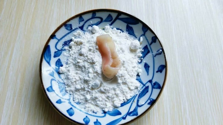 最受小朋友欢迎的&香炸鱿鱼圈,将腌制好的鱿鱼圈放入淀粉中，裹满淀粉。