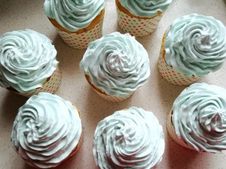 清新薄荷绿纸杯蛋糕,再把裱花袋中的奶油挤在纸杯蛋糕表面，然后洒上糖花装饰即可。
