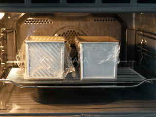 北海道吐司—附视频,盖上保鲜膜，将模具放在烤网上，置于烤箱底层