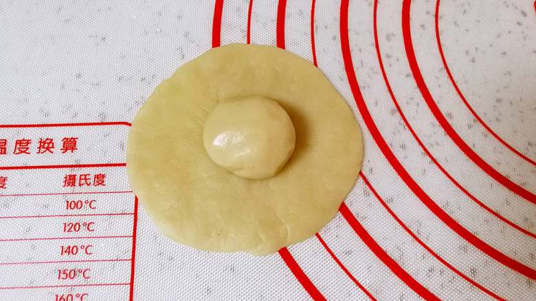 枣泥核桃绣球酥,分好的油皮搓圆压扁，放上一个油酥。