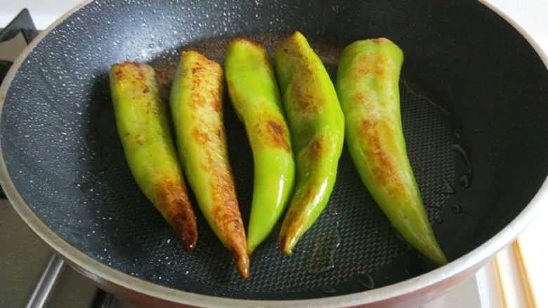新文美食  肉末虎皮尖椒,最后改成小火，煎制上色，煎制软嫩即可。