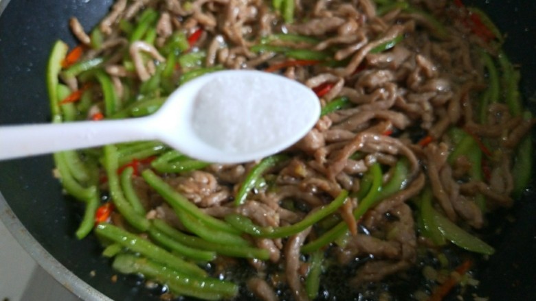 新文美食  青椒炒肉丝,加入适量盐。