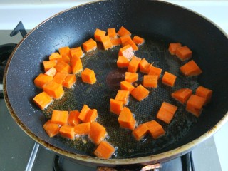 新文美食  清炒鸡丁,锅中在放适量油烧热，倒入胡萝卜炒软。
