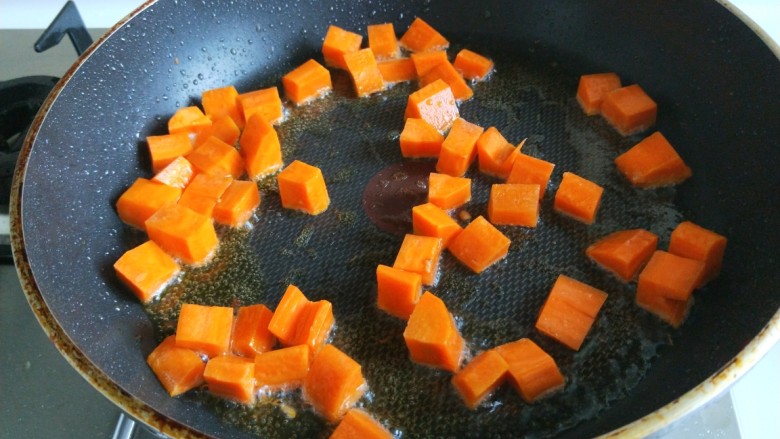 新文美食  清炒鸡丁,锅中在放适量油烧热，倒入胡萝卜炒软。