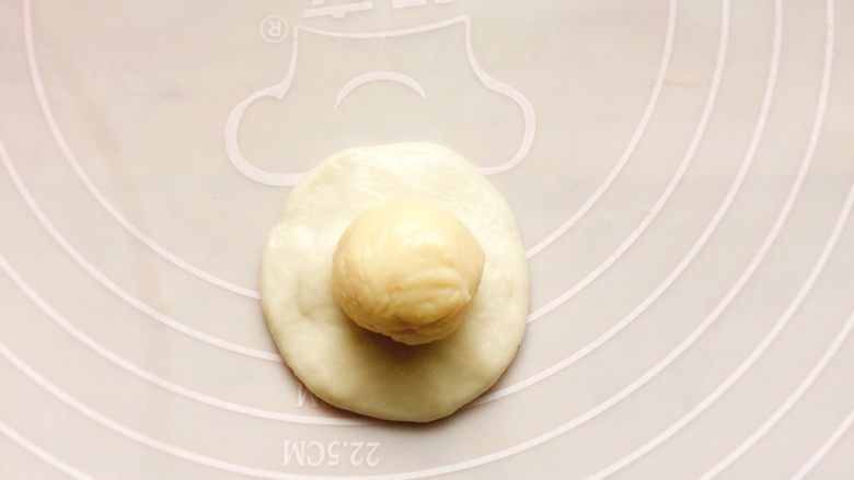 豆沙酥饼,取一份油皮，搓圆，按扁，包入一份油酥。