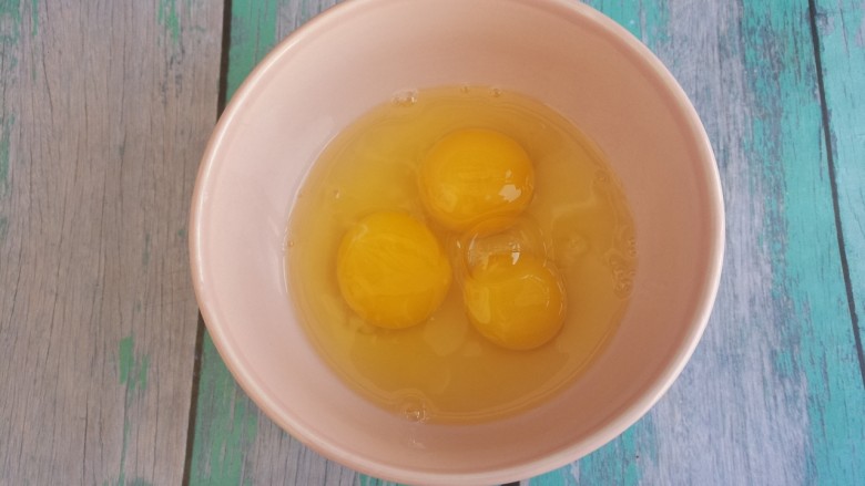 自制的葡萄干蛋挞,然后把鸡蛋打入碗中。