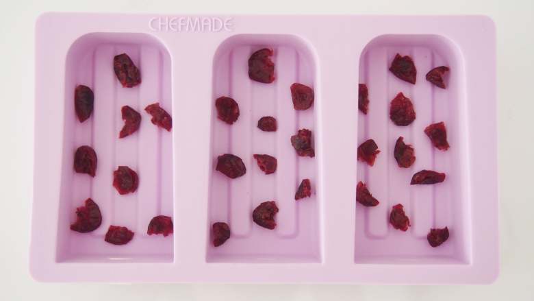 水晶冰糕,模具刷上一层油防粘，在底部铺上切碎的<a style='color:red;display:inline-block;' href='/shicai/ 660'>蔓越莓</a>。